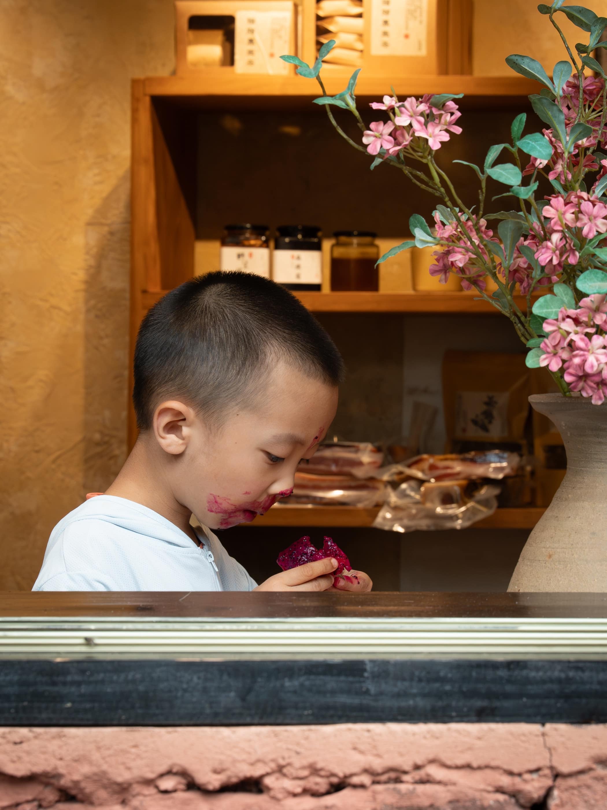 A child framed by a warm shop window in Dali