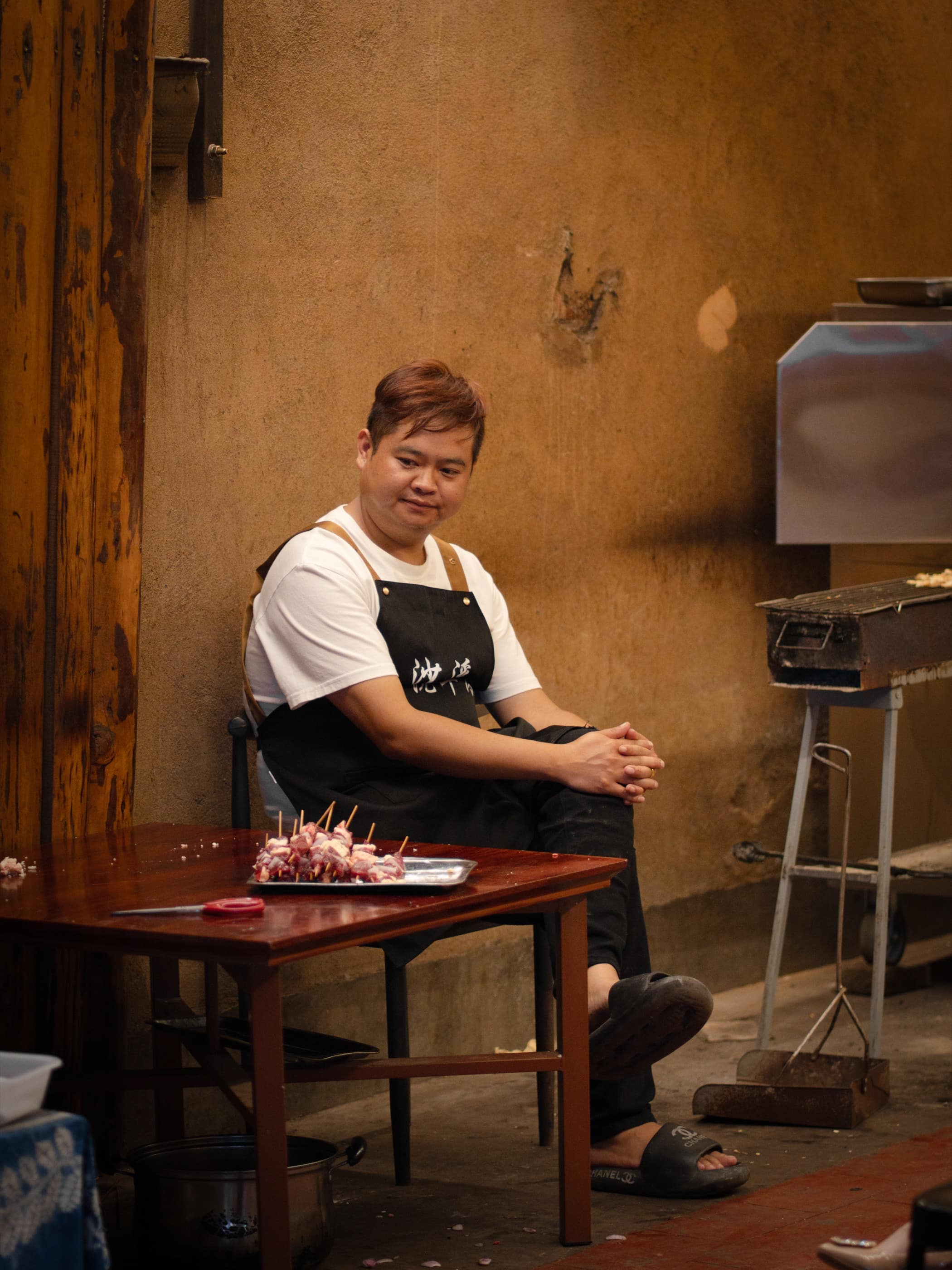 A cook preparing food in a warm courtyard
