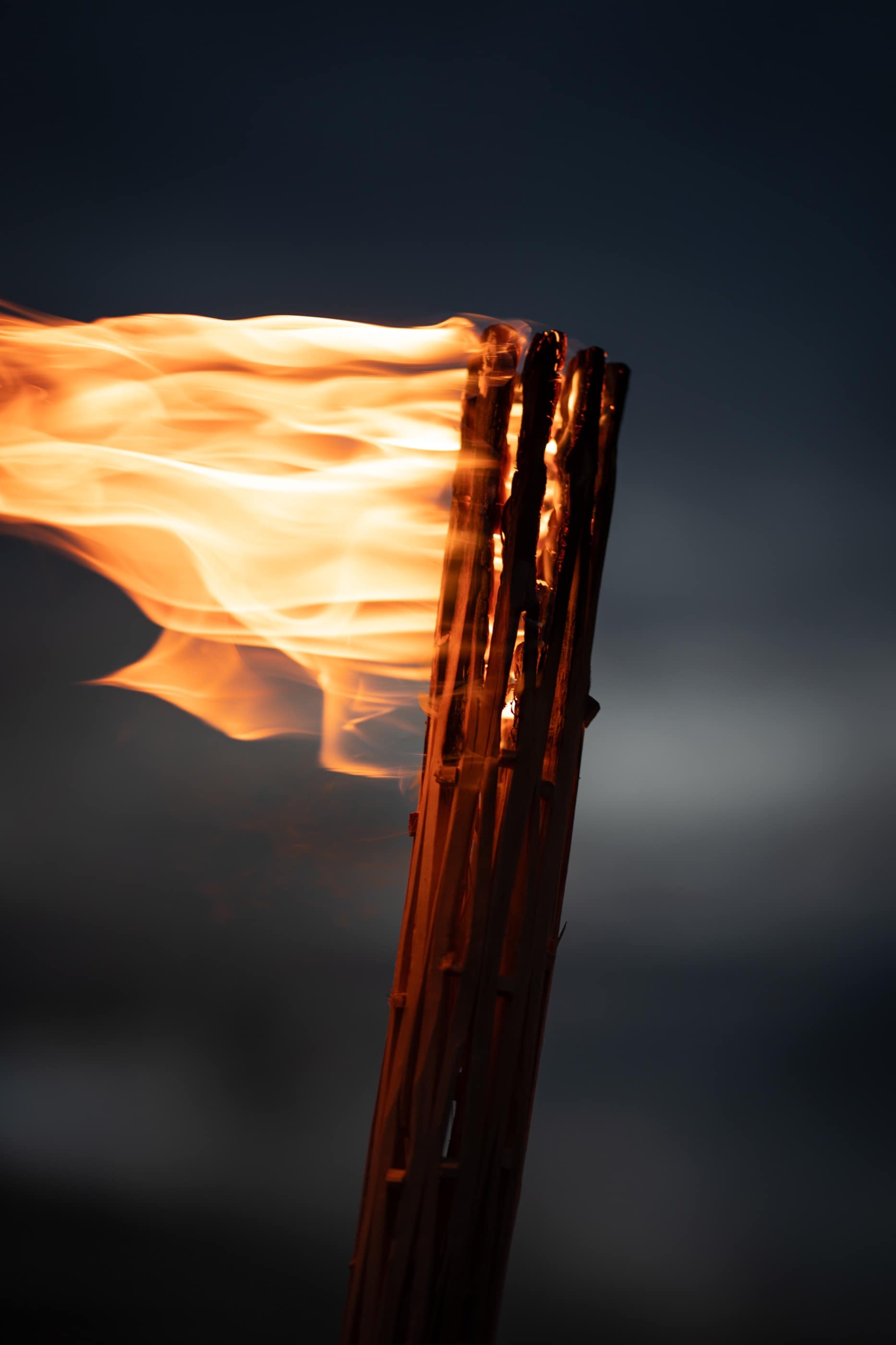 A windblown flame isolated against the night sky